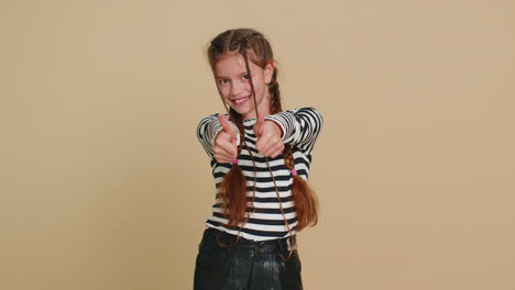 happy preteen child girl kid looking approvingly at camera showing thumbs up like positive sign