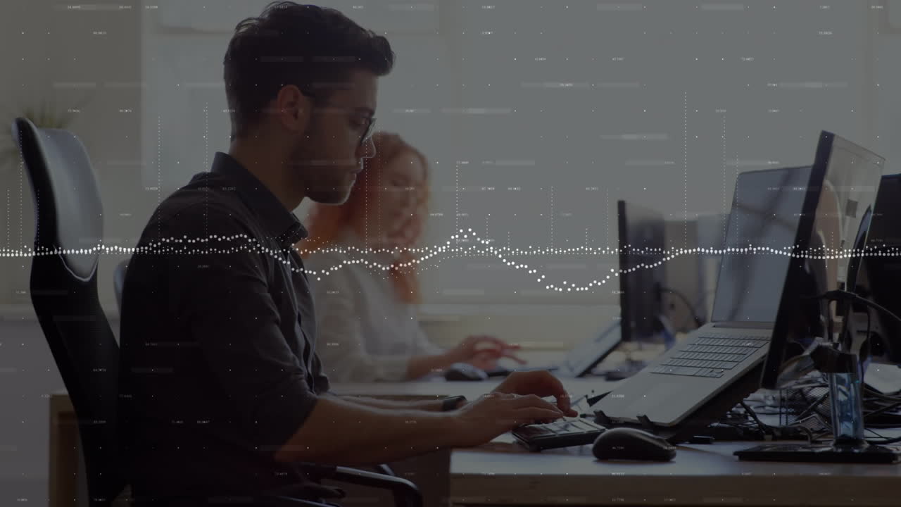 animación de gráficos y números cambiantes sobre un hombre biracial trabajando en una computadora portátil en la oficina