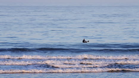 A-man-in-a-kayak-takes-a-rest-after-paddling-through-the-breaking-waves---California-lifestyle