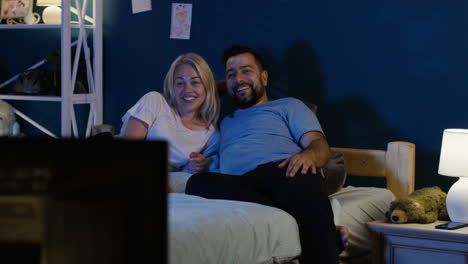 couple watching tv in bed at night