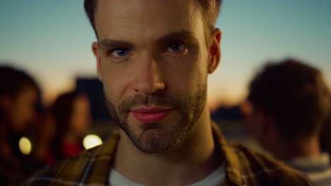 portrait handsome guy looking camera at party. attractive man posing outdoors.