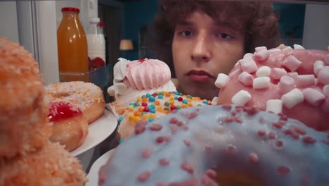 teenager sneaking donuts from the refrigerator