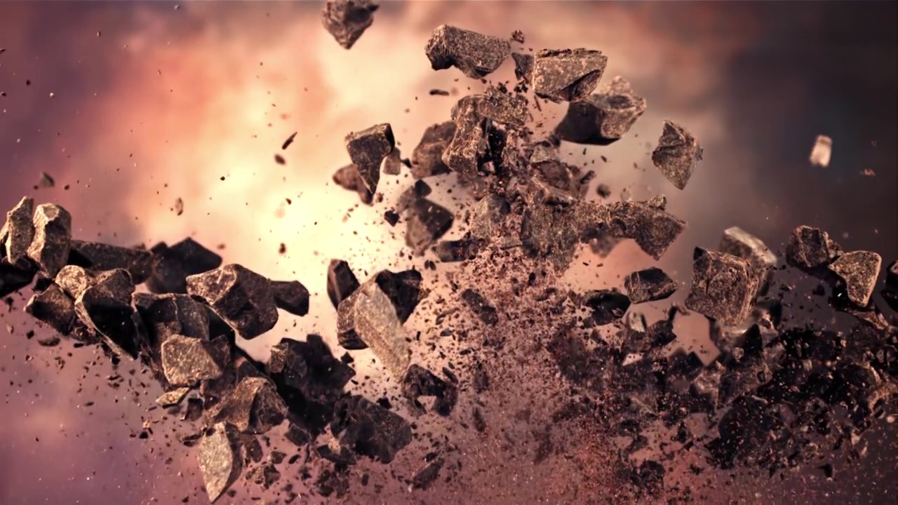 Esplosione al rallentatore di pezzi di cioccolato fondente e cacao in polvere