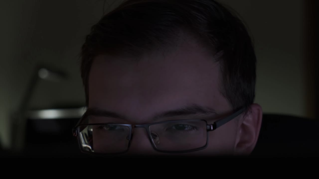 persona que trabaja tarde en la noche en una computadora portátil