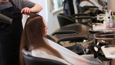 woman getting her hair styled and dried at a hair salon