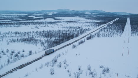 cinematic aerial shot of a truck travelling through a frozen landscape