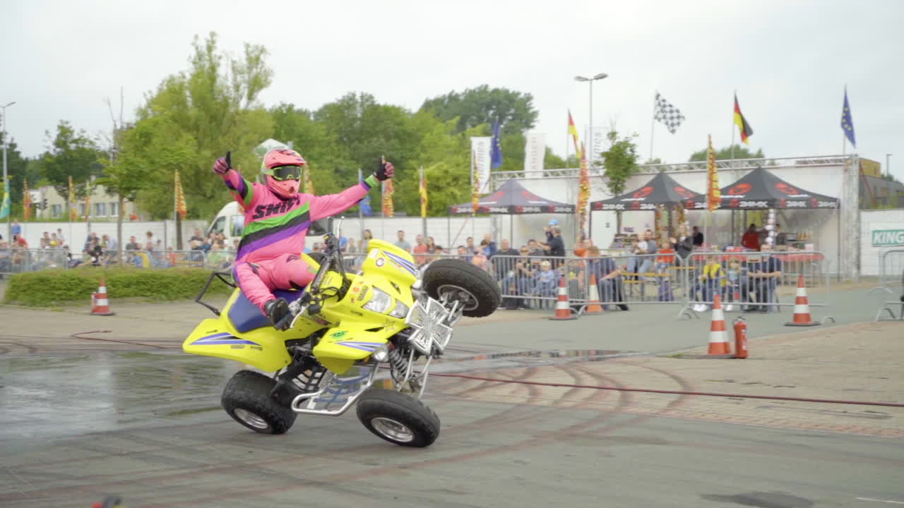 ATV Rider Performs Daring Wheelie at Outdoor Event