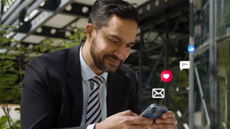 businessman sitting outside city offices looking at mobile phone with motion graphics emojis showing multiple messaging and social media notifications 1