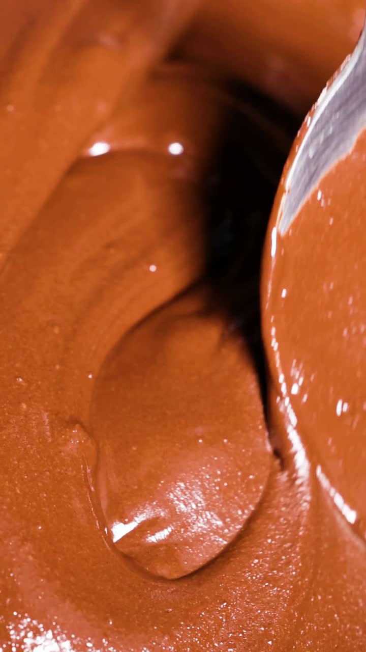 una cuchara agita el chocolate cremoso en un tazón