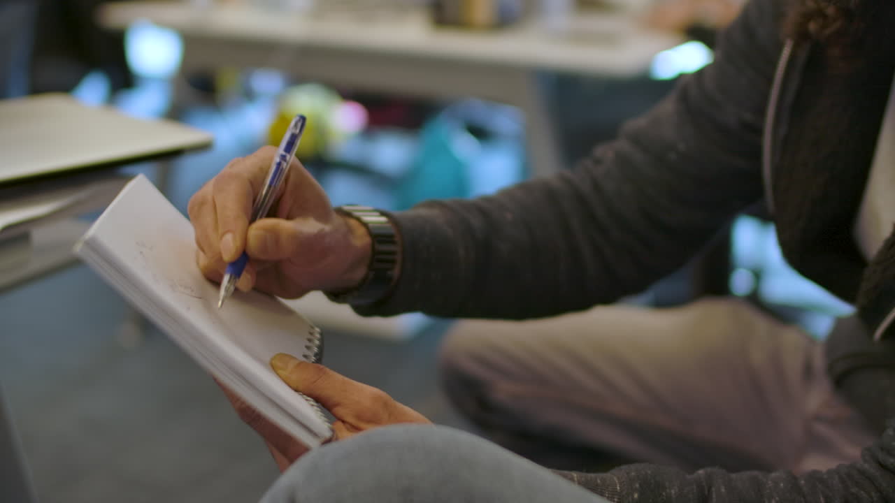 hombre dibujando en un bloc de notas con bolígrafo. de cerca