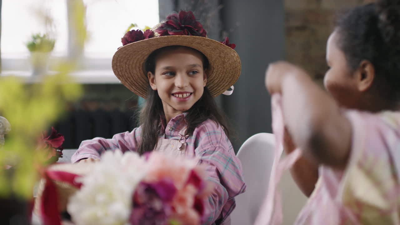 Girl Putting Straw Hat with Flowers on her Friend