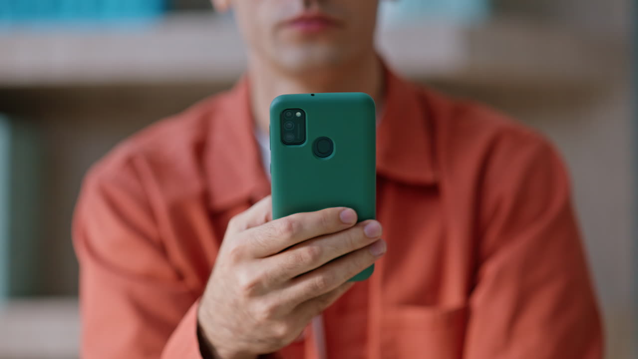 Businessman hand holding mobile phone at company workplace closeup crop view