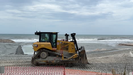 bulldozer working on beach near ocean