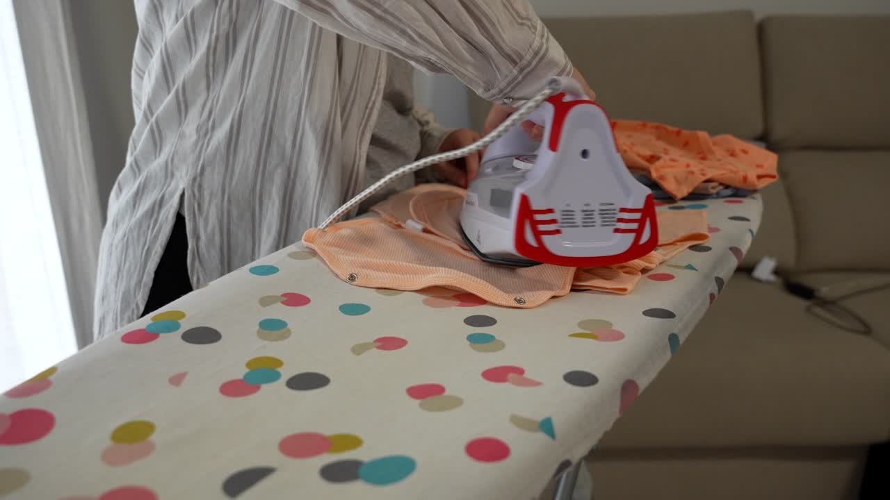 Female hands ironing bodies for a baby. Close up