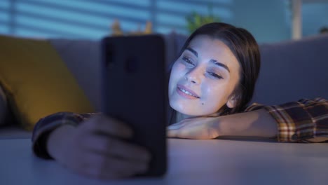 Mujer-Joven-Tirada-En-El-Suelo-Charlando-Y-Enviando-Mensajes-De-Texto-Usando-Un-Teléfono-Inteligente.