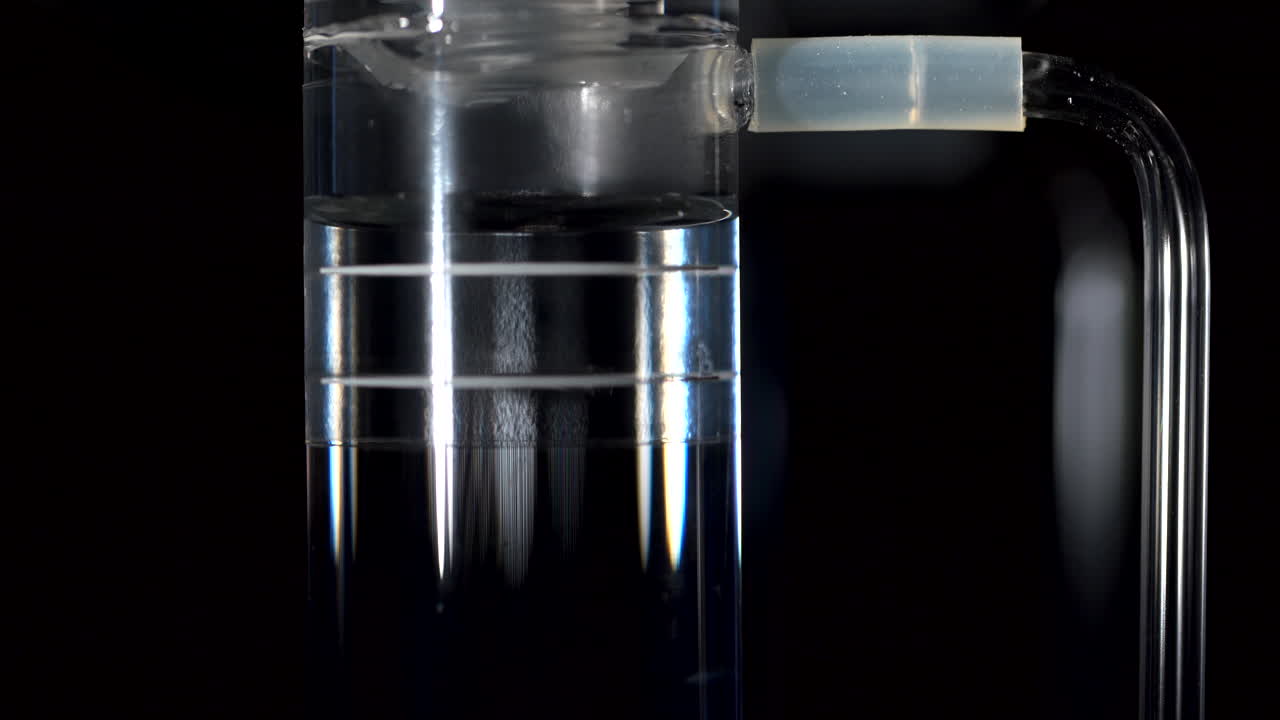 Air bubbles surface up through water inside a science tube. A detail from a science solar powered experiment.