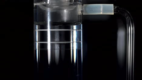 air bubbles surface up through water inside a science tube. a detail from a science solar powered experiment.