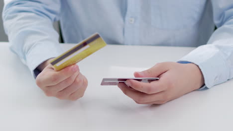 male hand examining multiple credit cards in a close-up, concept of e-commerce and digital payment in modern technology