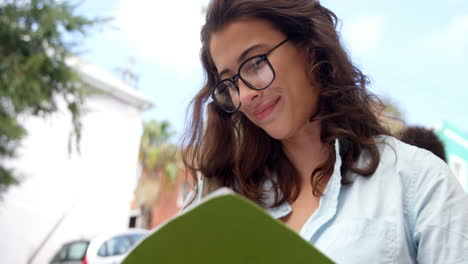 una mujer hermosa sonriendo mientras lee un libro.