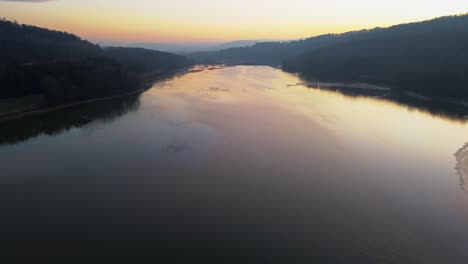 dusk reflections on a tranquil river amidst forested hills