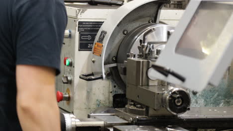 técnico programando una máquina de precisión cnc dentro de una fábrica moderna durante el turno de trabajo