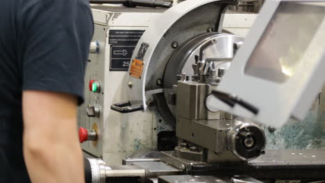 technician programming a cnc precision machine inside a modern factory during job shift