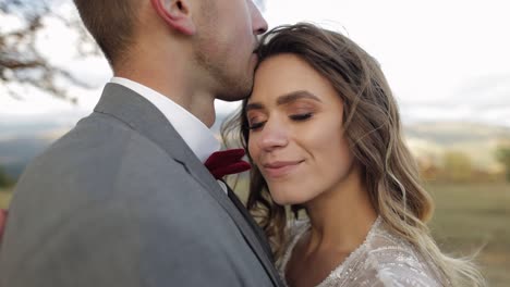 bellissimi giovani sposi sposa e sposo che si abbracciano, abbracciati sul pendio della montagna, coppia di sposi innamorati