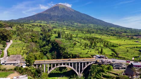 aerial view of a bridge and volcano in bali, indonesia