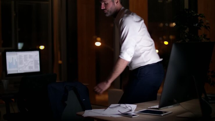 Uomo d'affari maturo che lascia il suo ufficio di notte