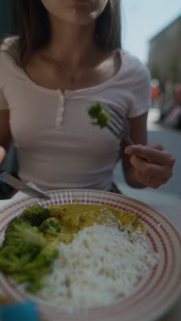 woman eating curry and rice
