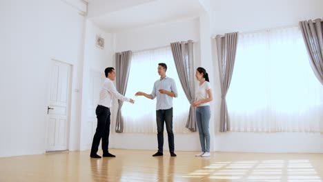 asian agent giving keys of new house and handshake with customer