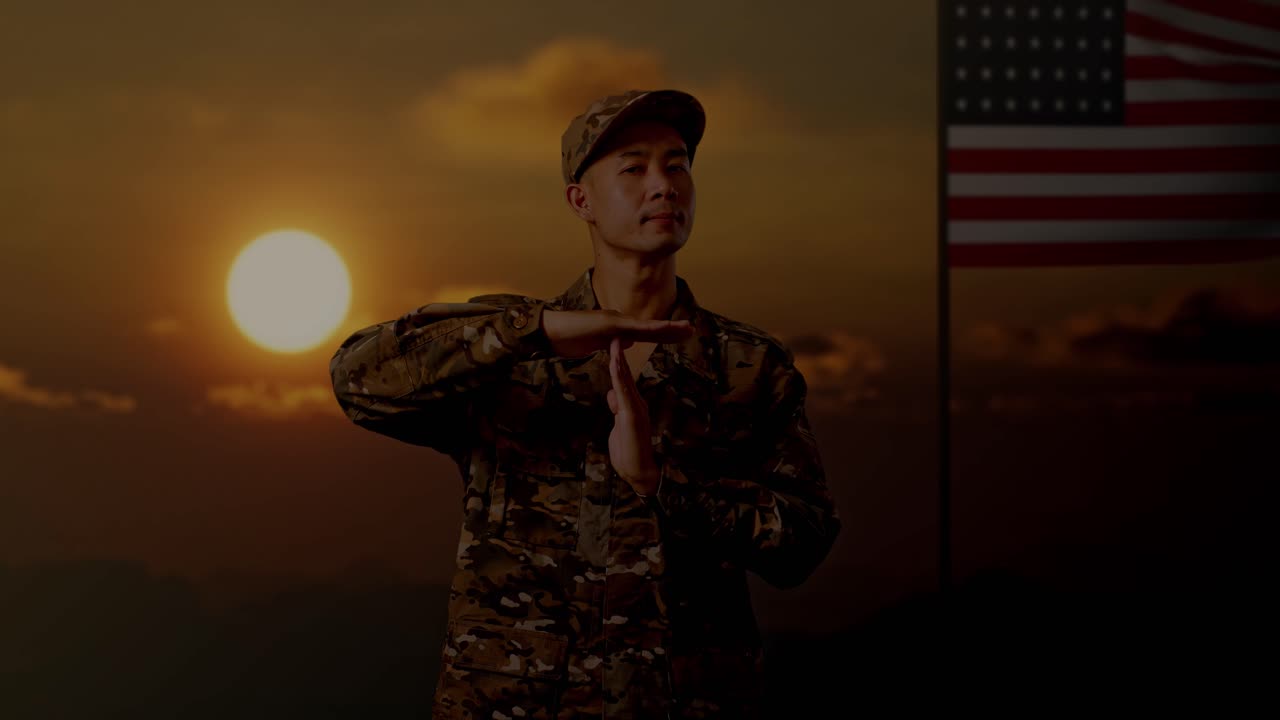 Personale militare in uniforme mimetica che segnala il 'time out' al tramonto con sfondo di bandiera americana