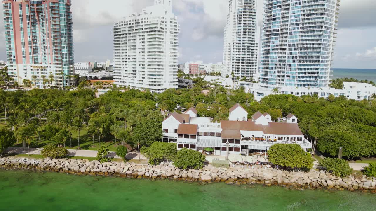 배경 에 초고층 빌딩 이 있는 해변 물 에 있는 레스토랑