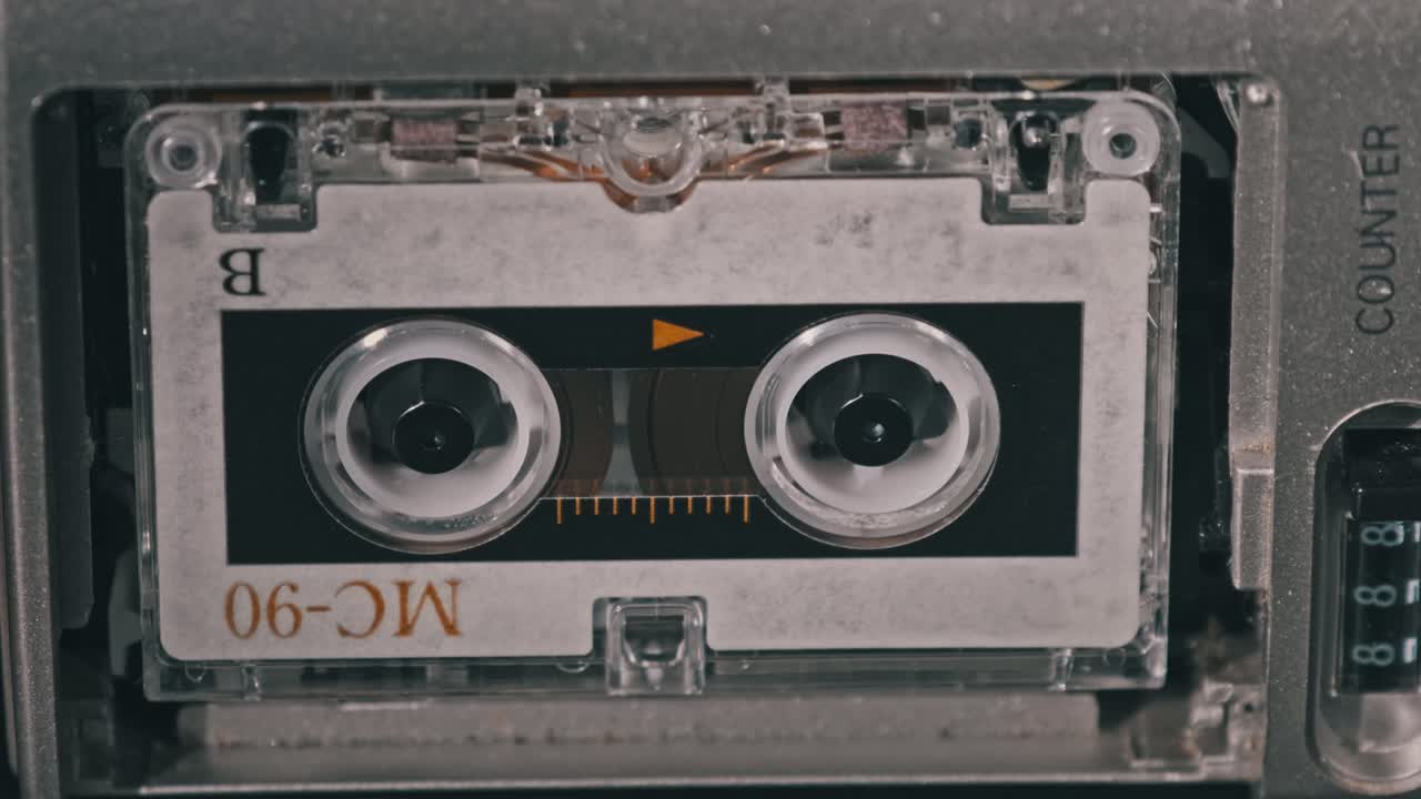 cinta de audio vintage con una etiqueta en blanco girando en la grabadora de cassette, primer plano
