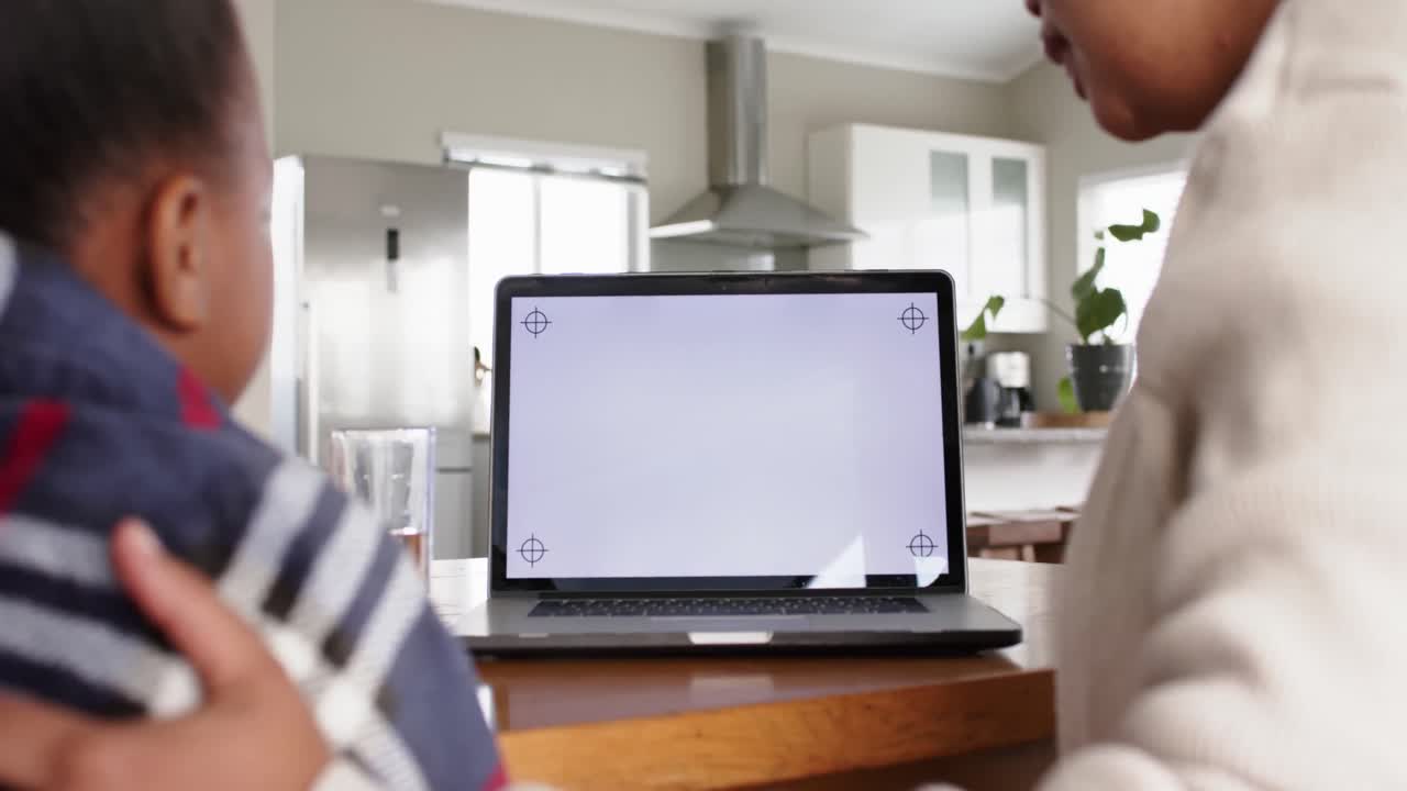 Unaltered african american mother and sick daughter using laptop with copy space, in slow motion