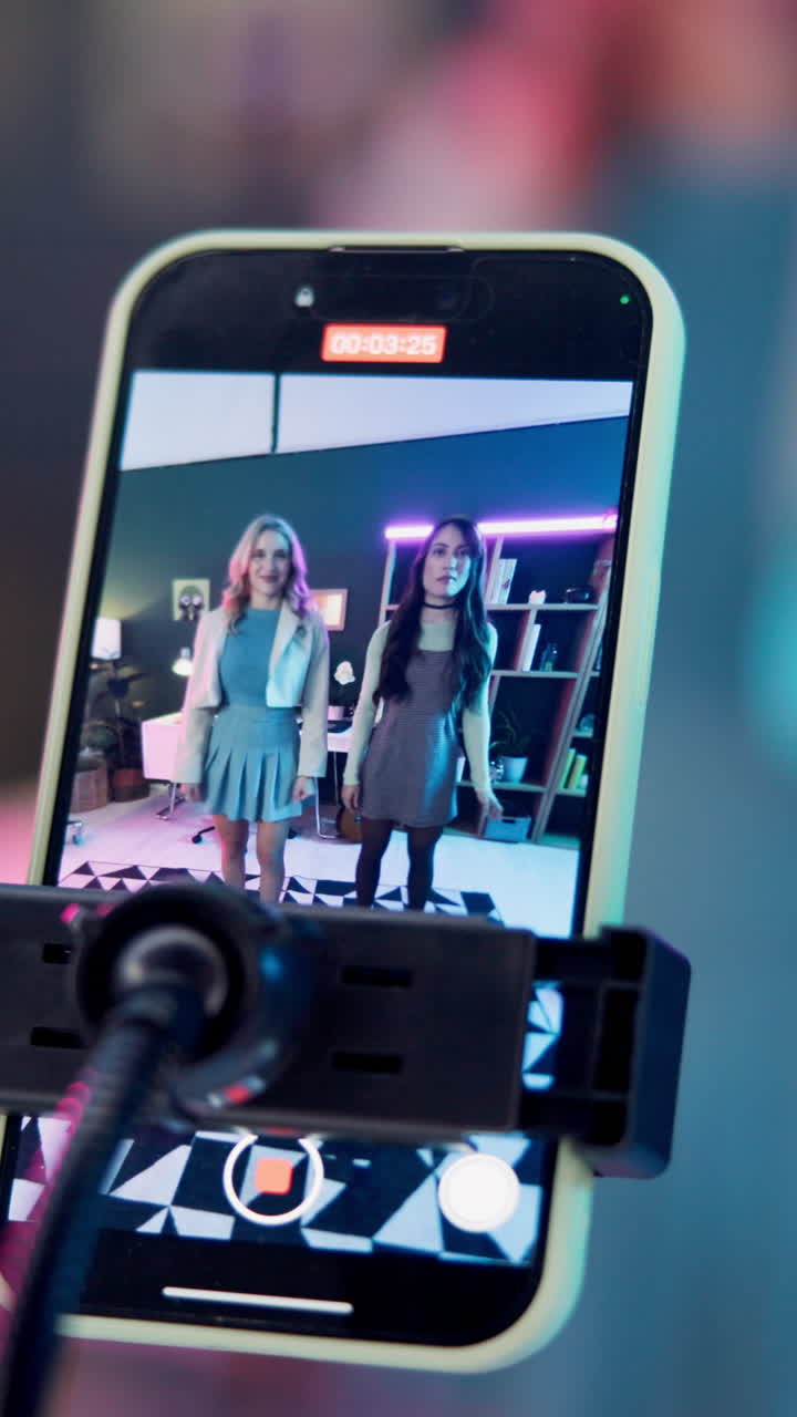 Due donne che ballano di fronte alla fotocamera di uno smartphone