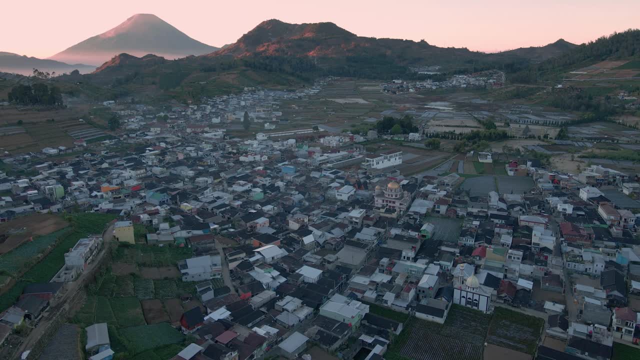 sobrevolar un pueblo en indonesia con una hermosa vista de la cordillera en el amanecer - 4k drone shot de la meseta de dieng