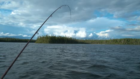 barco tambaleante con un camino de pesca doblado en un lago