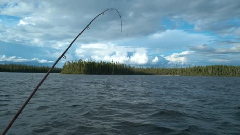 wobbling boat with a bent fishing road on a lake