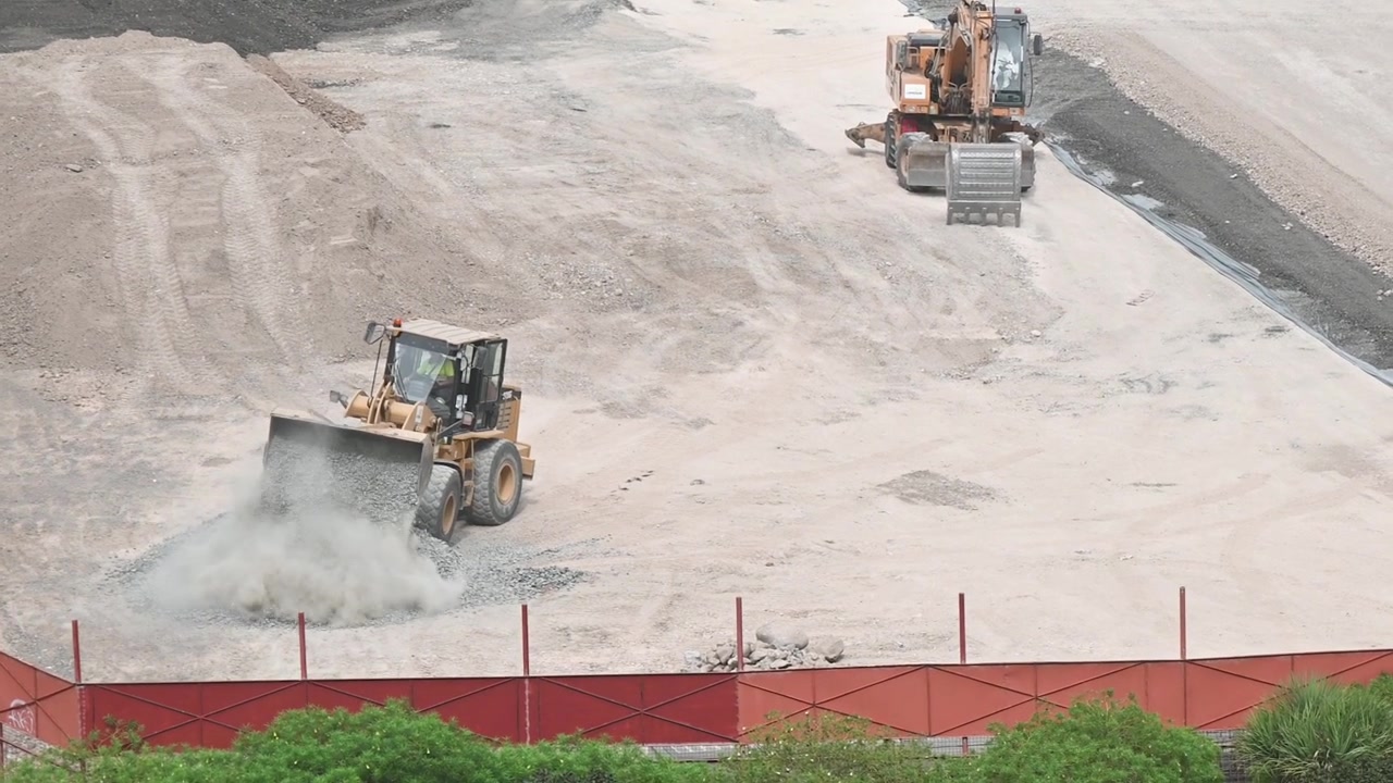 Tractors working on a football field moving soil and sand