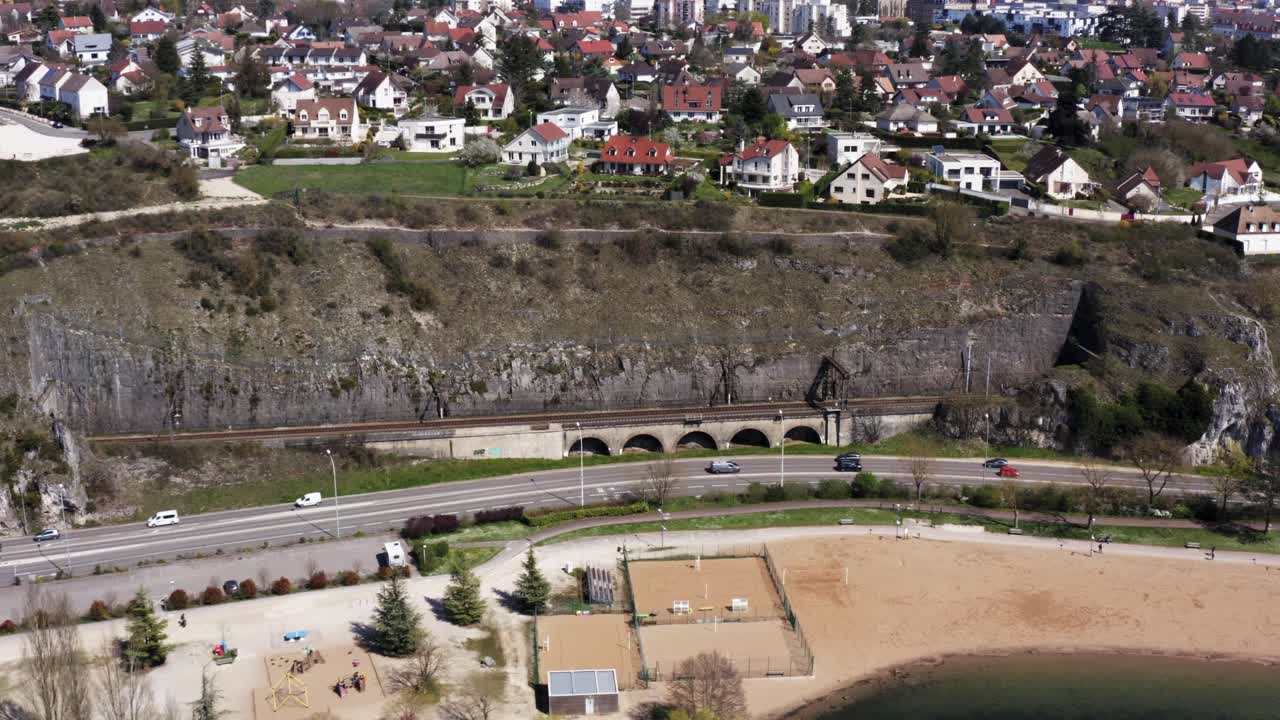 carretera con tráfico por debajo de la ciudad en el acantilado