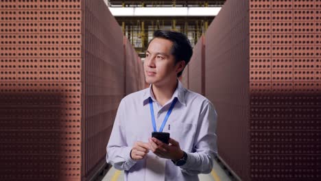 trabajador de una fábrica que usa un teléfono inteligente