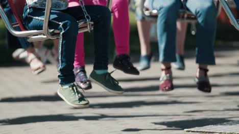 pies de niños sentados en el carrusel en la atracción del parque