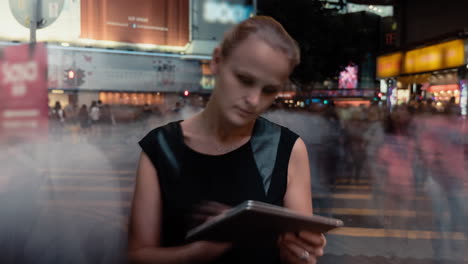 timelapse of woman with pad in night crowded street