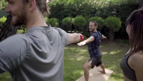 female yoga trainer exercising with people in park