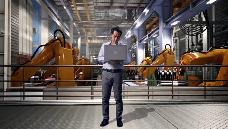 full body of an asian male professional worker standing with his laptop with industrial robotic arms working, he is nodding his head with dissapionted