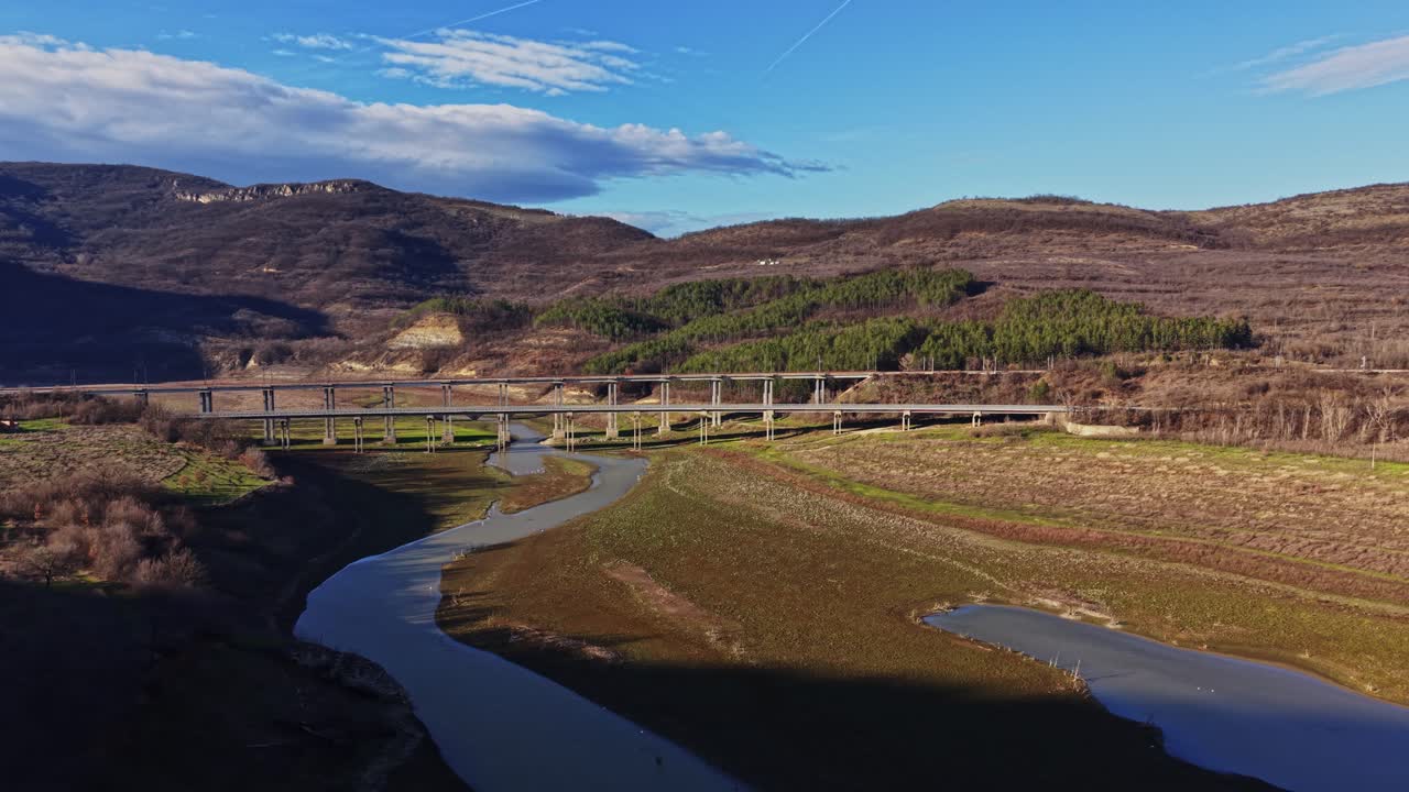 Vista panorâmica de uma ponte sobre um rio com montanhas ao fundo