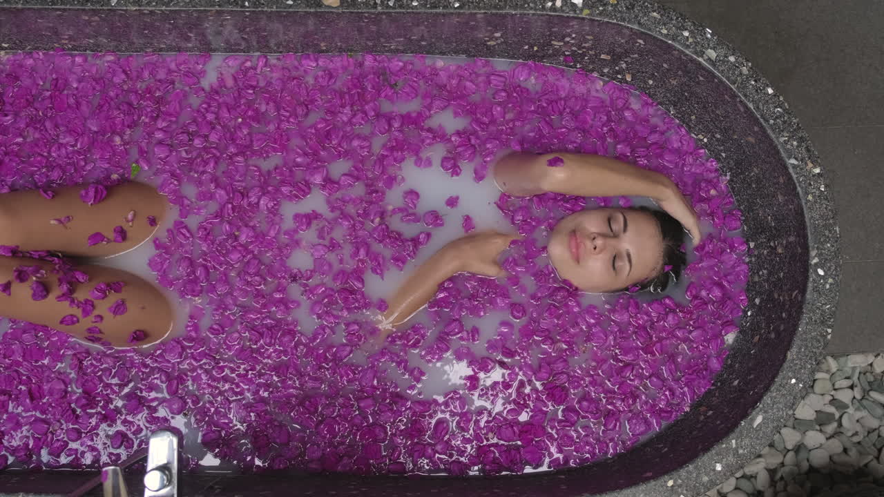 Woman enjoying a relaxing milk bath with flowers
