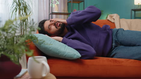 scared tired indian man wakes up from bad nightmare in bedroom at home stress nervousness anxiety