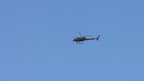 un helicóptero avanza a través de un cielo soleado y salpicado de nubes